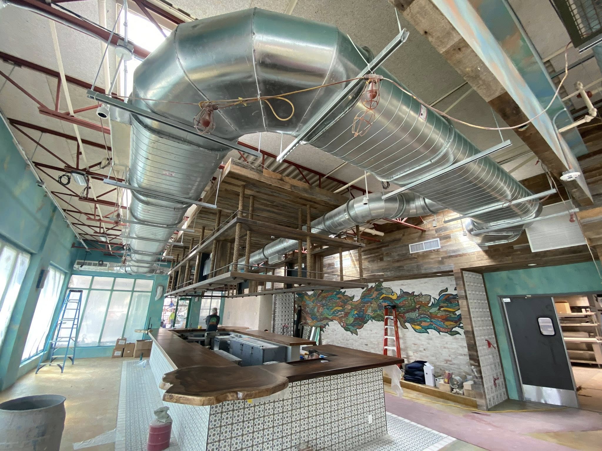 Exposed spiral and rectangular ductwork over the bar at the Baresco Restaurant build-out