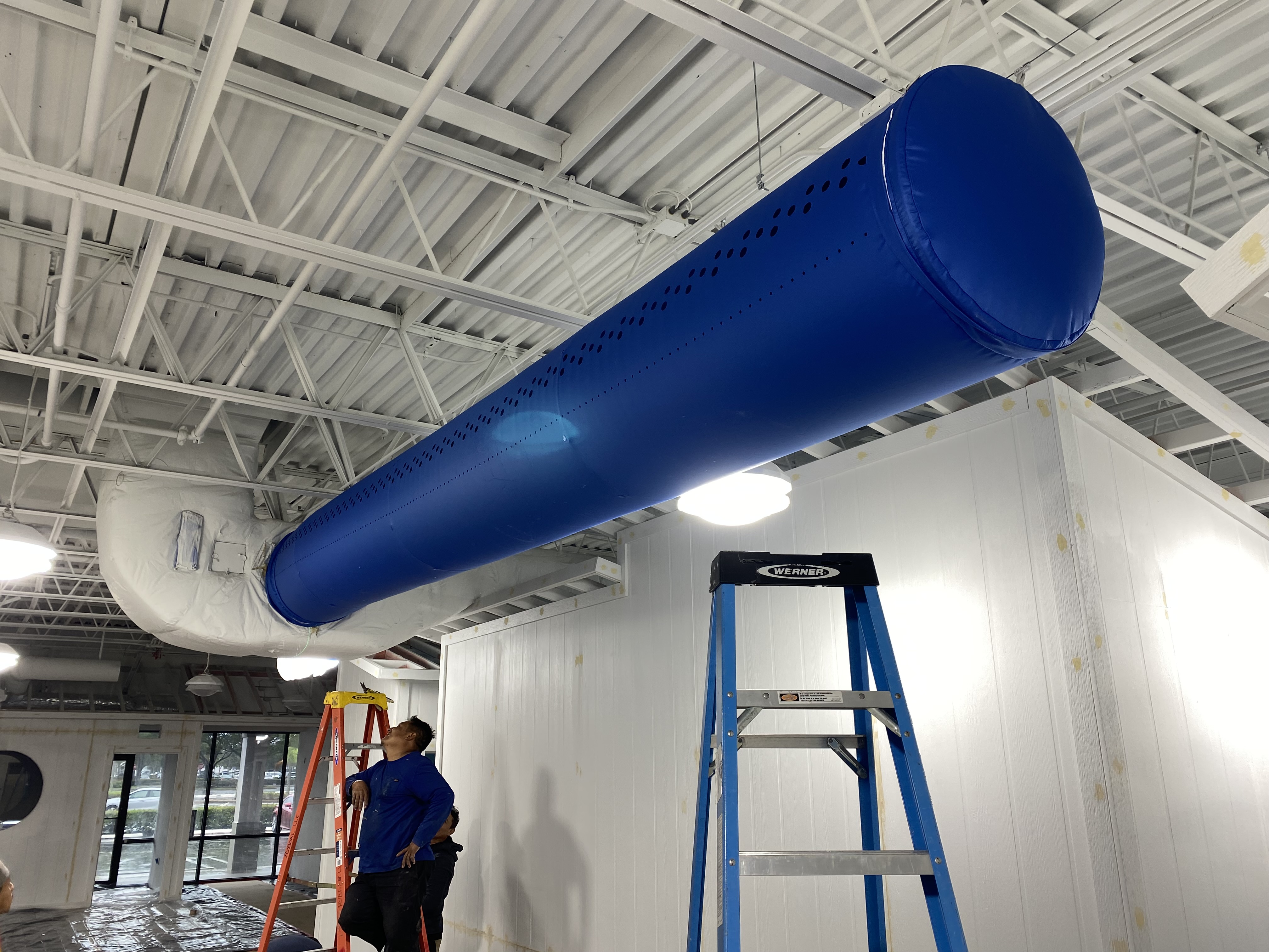 CFM technician inspecting a fabric duct sock installation