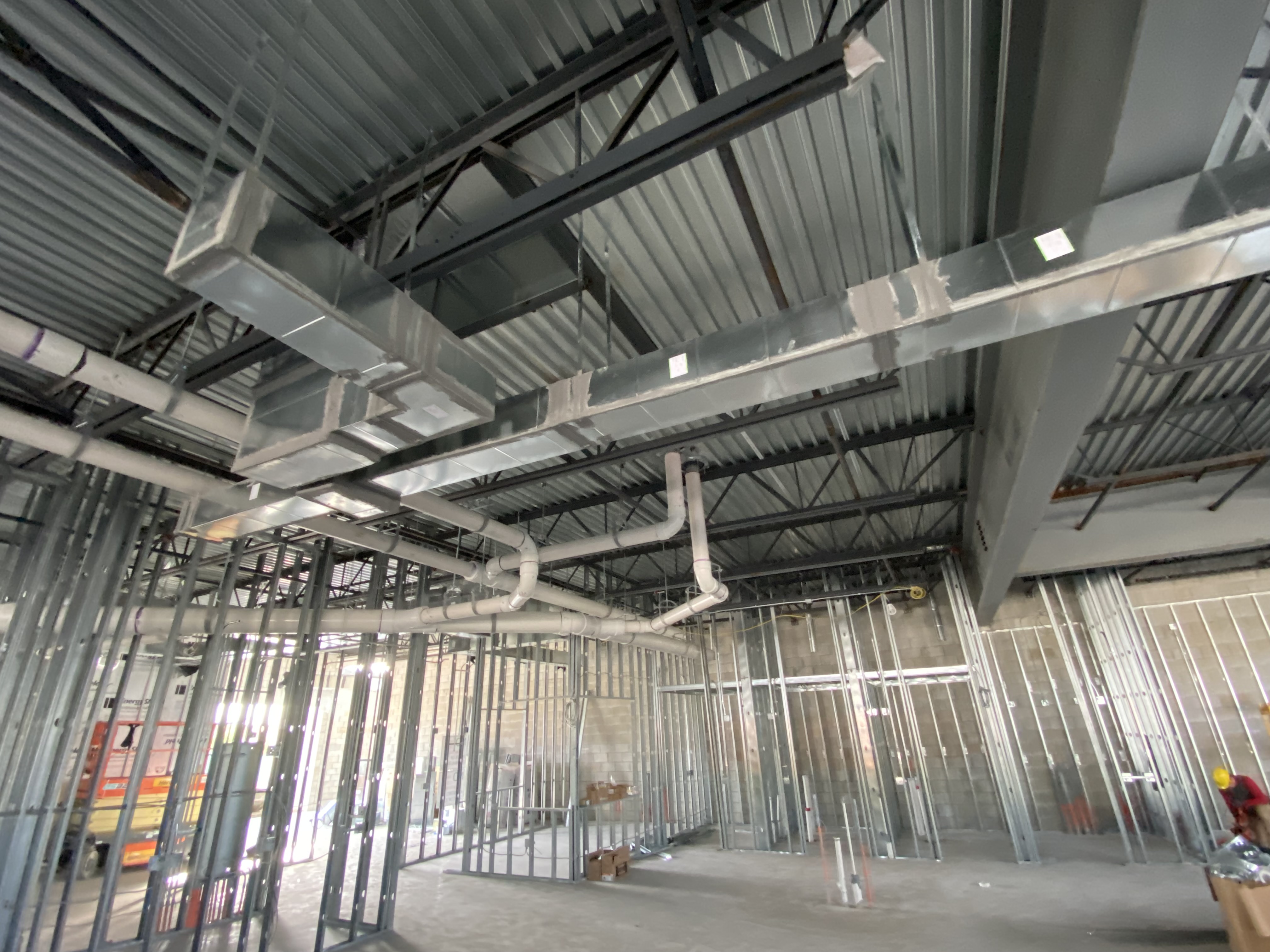 Ductwork and piping rough-in above steel stud framing at a Radiation Imaging Partners facility