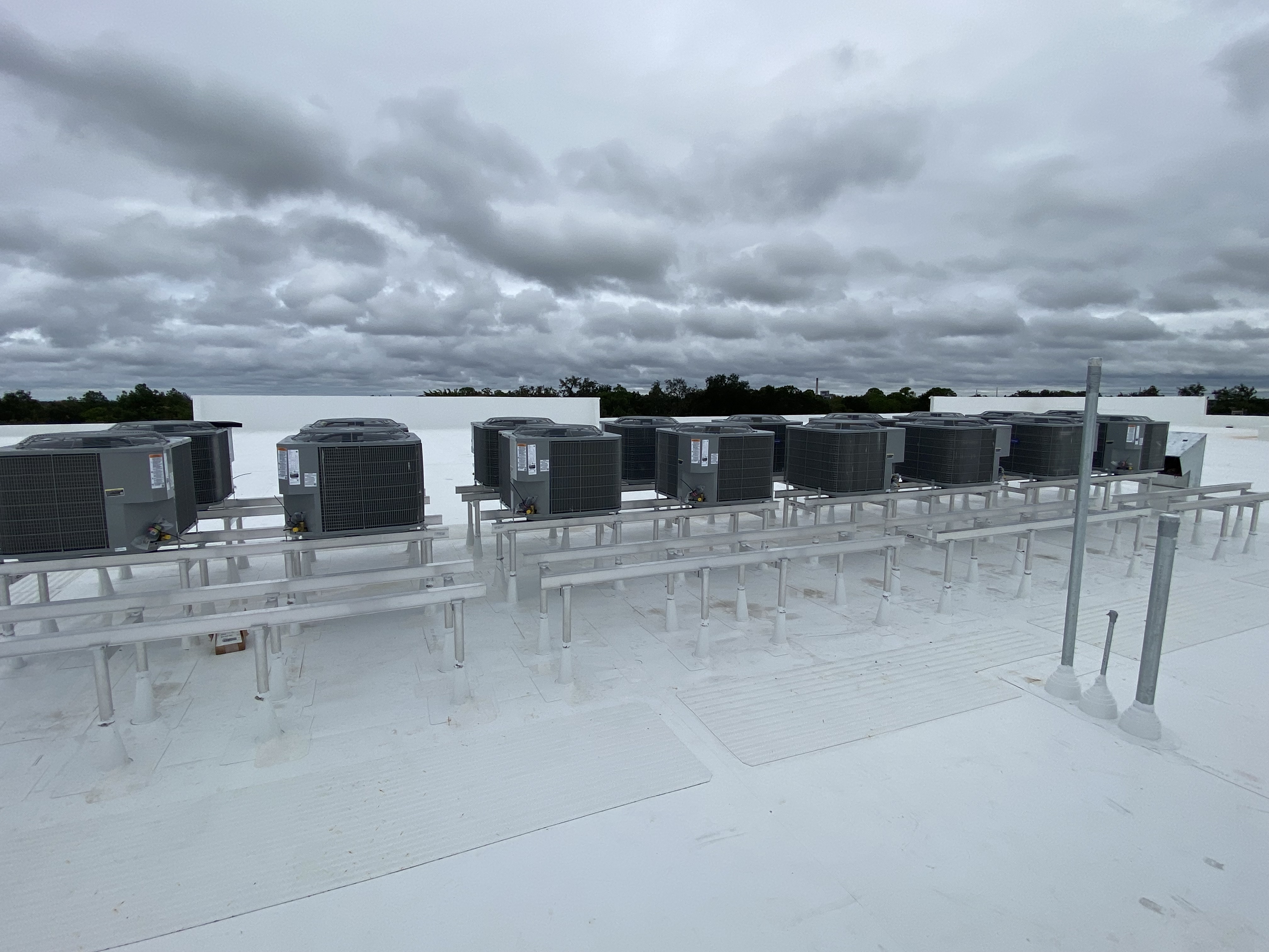 Rows of rooftop condensing units on equipment stands at a Space Box Storage facility